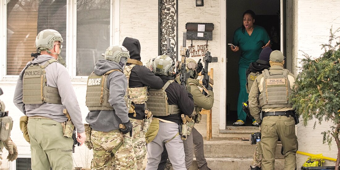 Agentes federales de inmigración de EU derriban una puerta antes de un arresto, en Minneapolis el domingo 11 de enero de 2026.