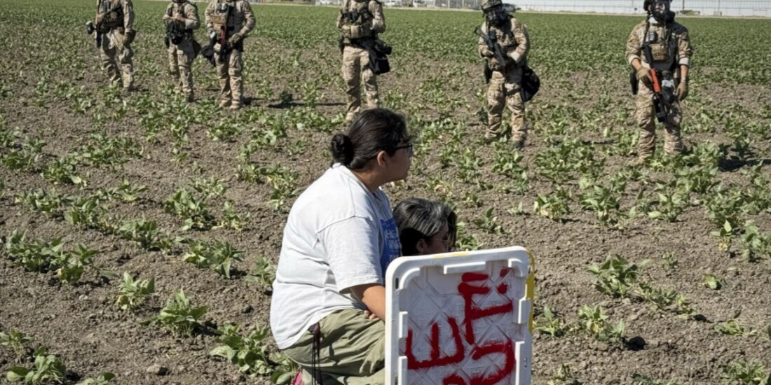 Dos migrantes se hincan ante agentes federales, en una redada el pasado 10 de julio, en California.