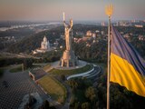 La bandera ucraniana ondea mientras trabajadores instalan el escudo del país en la estatua más alta del país, la estatua de la Madre Ucrania, luego de que retiraron el martillo y la hoz soviéticos, el domingo 6 de agosto de 2023, en Kiev. (AP Foto/Efrem Lukatsky)