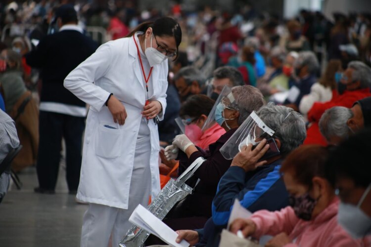 Personal de salud que aplica la vacuna Covid conversa con adultos mayores en el Deportivo las América de Ecatepec.