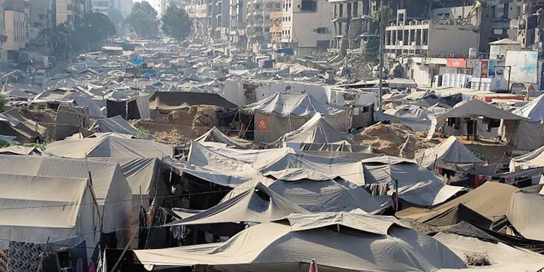 Gazatíes desplazados por la ofensiva militar israelí se refugian en un campamento de tiendas de campaña, ayer.