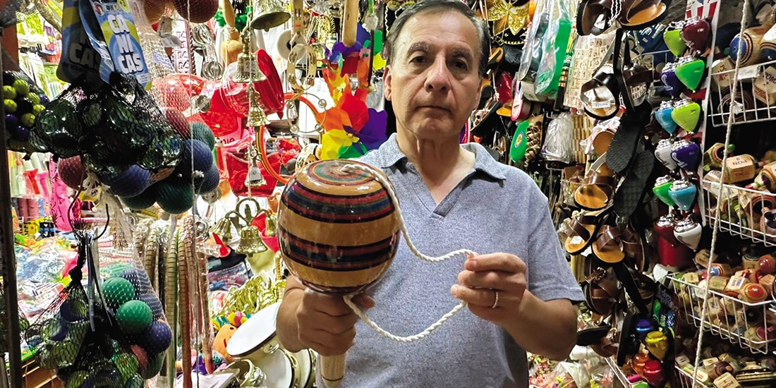 Andrés Díaz sostiene un balero gigante que vende en su tienda.