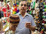 Andrés Díaz sostiene un balero gigante que vende en su tienda.