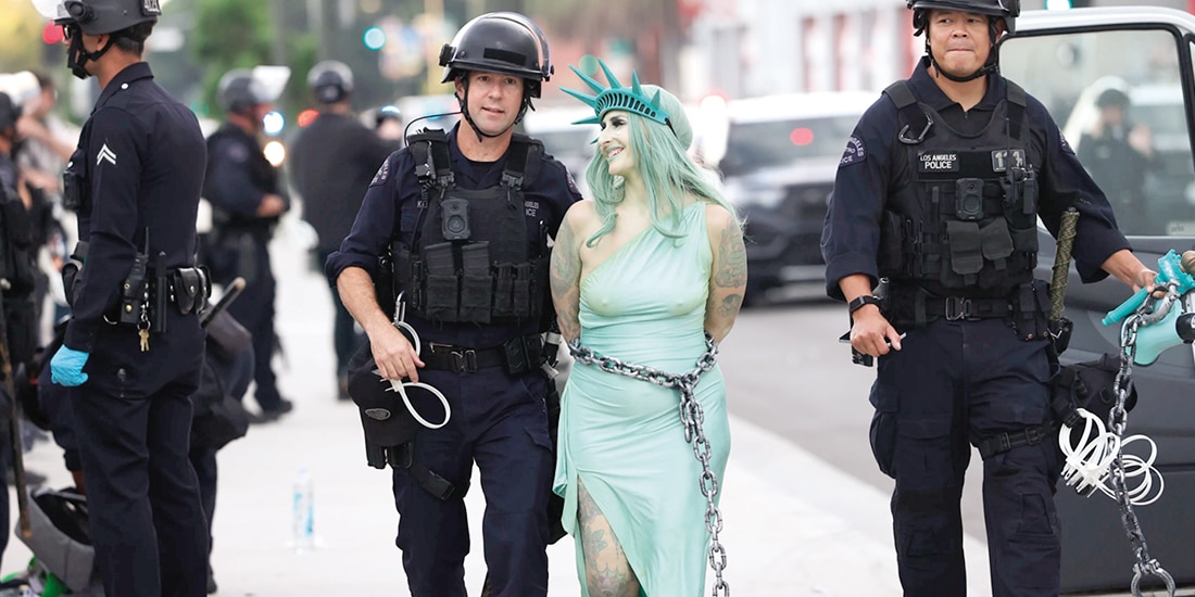 Policía arresta a una manifestante disfrazada de la Estatua de la Libertad, el sábado.