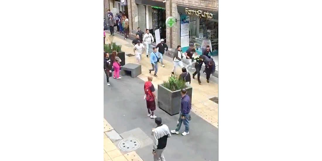 Momento en el cual cerca de una decena de sujetos golpea a dos uniformados, ayer, en el Centro Histórico.