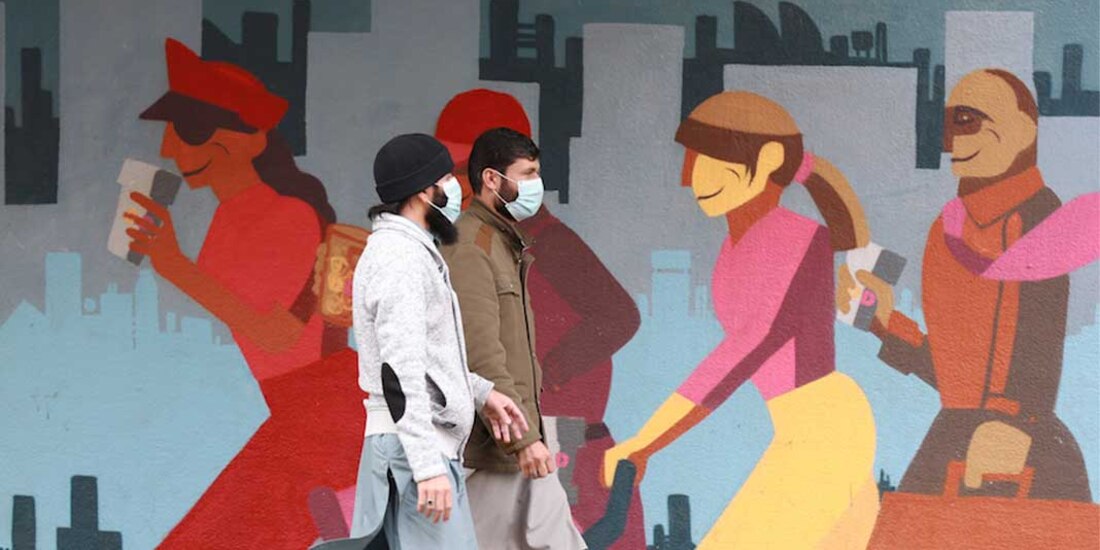 Dos hombres pasean en Ciudad del Cabo, Sudáfrica, con cubrebocas, el 27 de mayo de 2020.