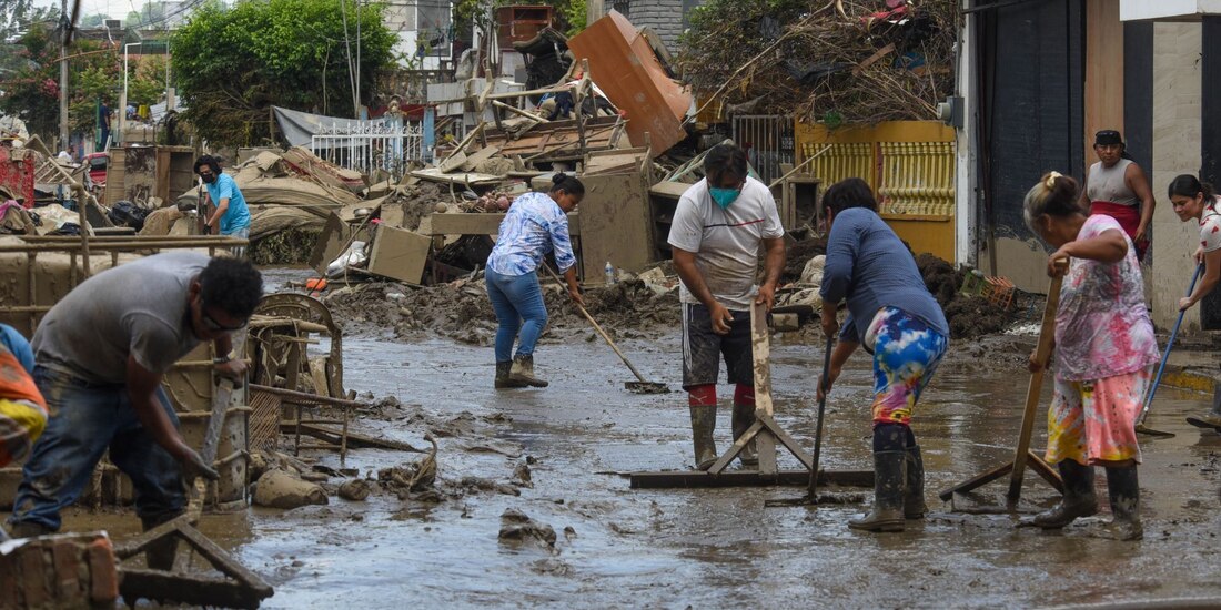 Habitantes realizan labores de limpieza en sus casas, tras intensas lluvias, en Poza Rica, Veracruz.
