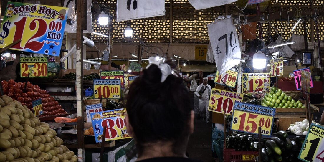 Una mujer revisa los precios de venta de un mercado.