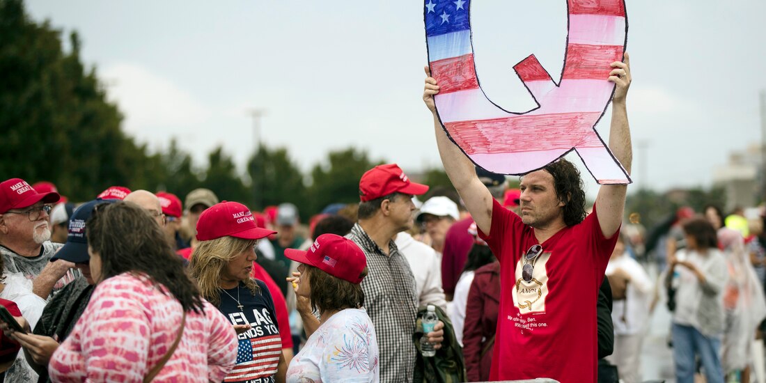 Una persona sostiene en lo alto una Q, en un acto de campaña del presidente Donald Trump, el 2 de agosto de 2018.