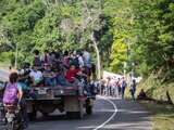Migrantes abordan camiones para llegar a la frontera de Guatemala con México.