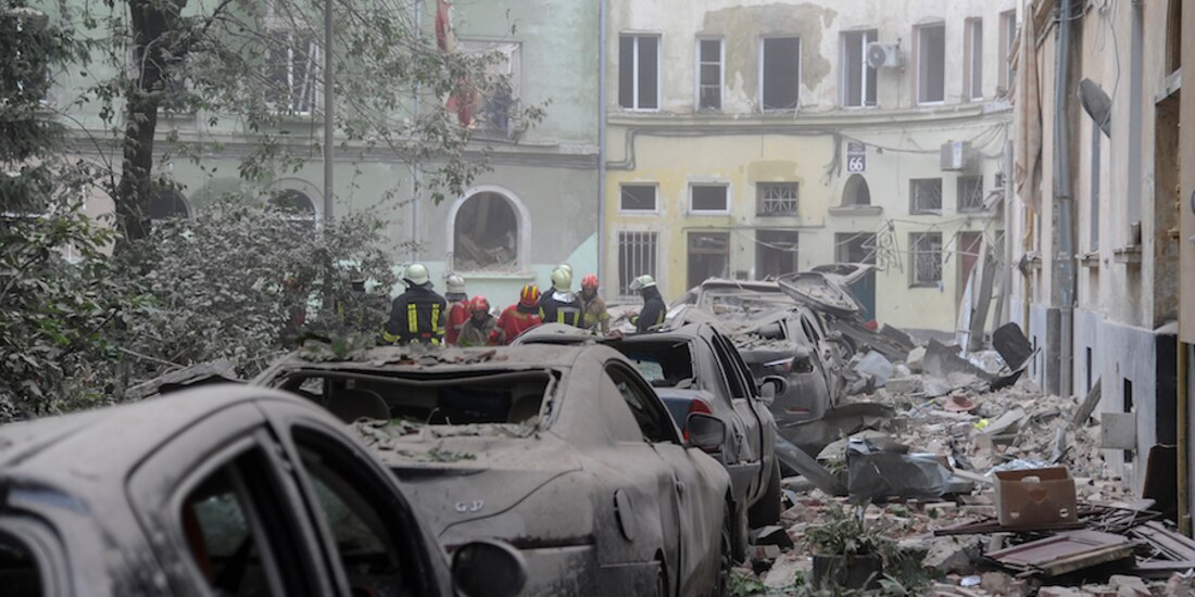 Entre autos cubiertos de escombros, bomberos mantienen rescate en Leópolis, ayer.