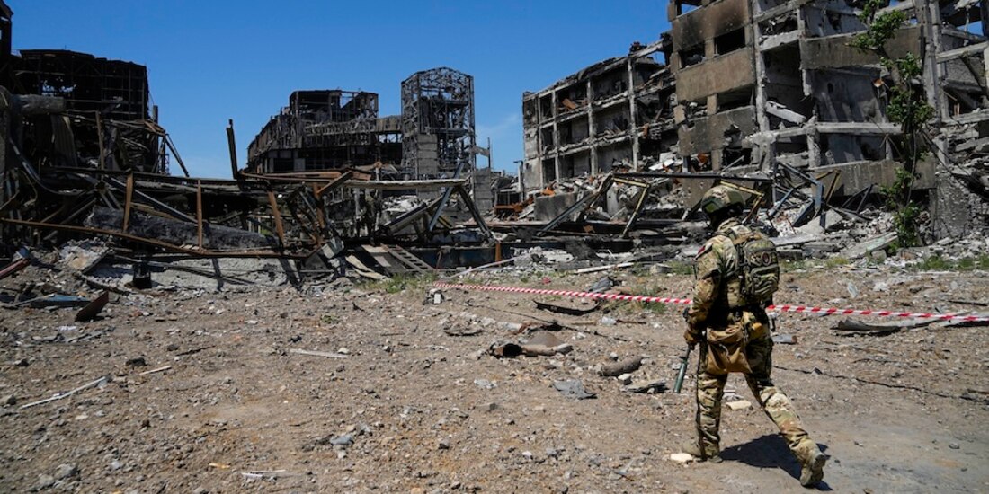 Un soldado ruso se pasea entre inmuebles dañados como la planta de Azovstal, ayer.