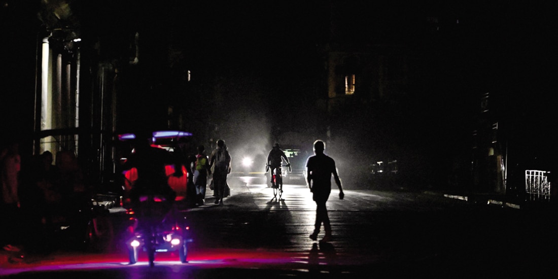 La gente camina y conduce por una calle mientras la red eléctrica nacional de Cuba se derrumba por segunda vez en una semana, el 21 de marzo pasado.