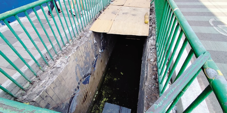 Dos personas pasan a un costado de un bajopuente inundado, el miércoles.