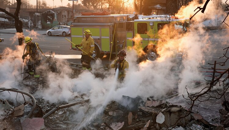 Bomberos extinguen un incendio en una estructura en Eaton, California.