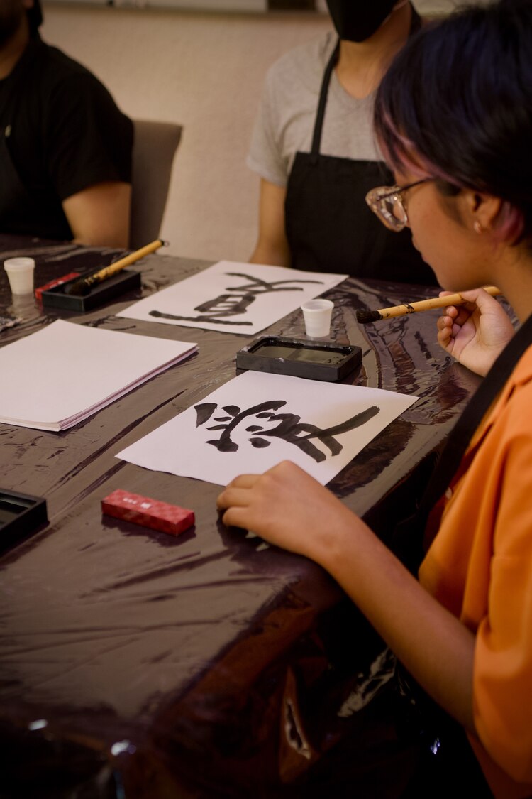 Realizan talleres de escritura con pincel.