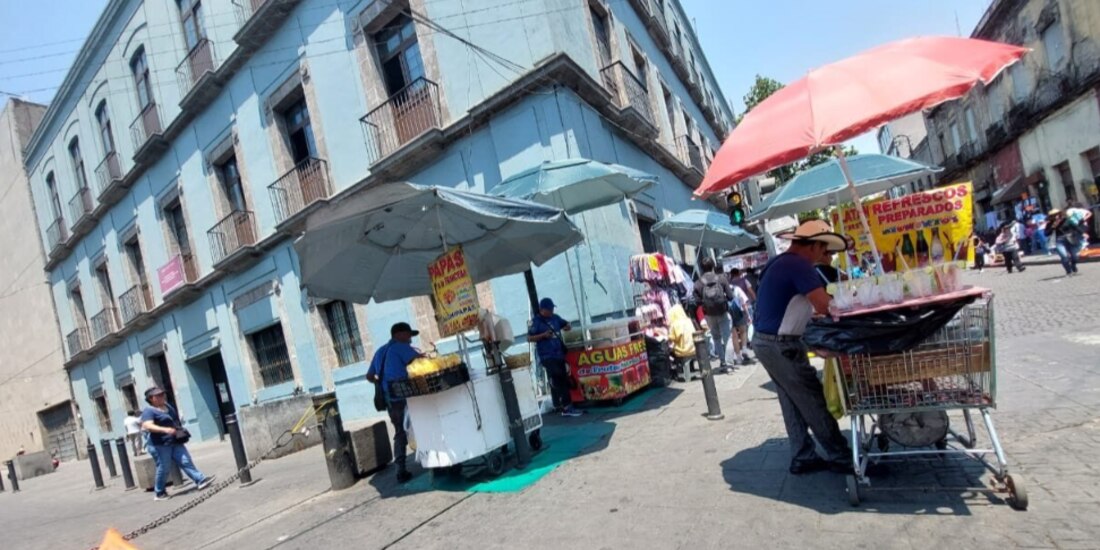 Vendedores de dulces, refrescos y frituras esperan la salida de estudiantes de la Secundaria Técnica 63, Melchor Ocampo, en el Centro Histórico de la CDMX, ayer.