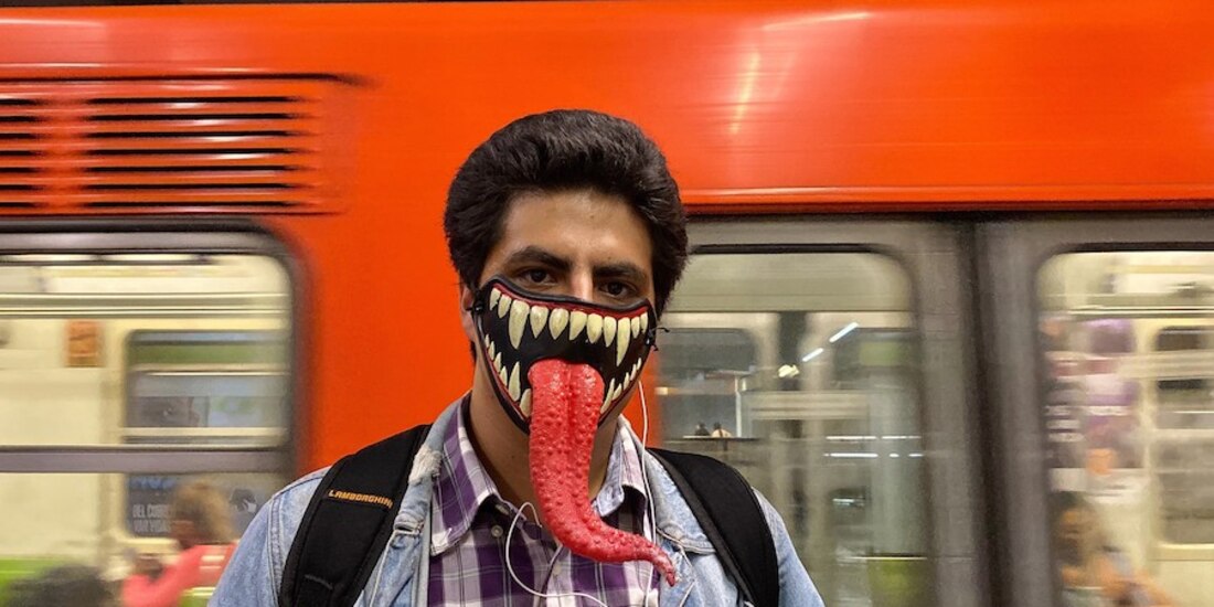 Un joven posa con un cubrebocas decorativo, después de transbordar en la Línea 3 del Metro, en octubre.