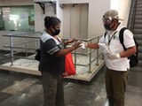 Pasajera recibe un cubrebocas después de colocarse gel antibacterial en las manos.