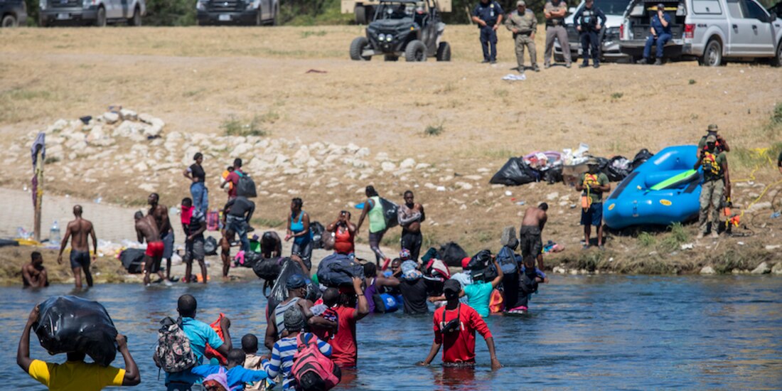 Pese al reforzamiento de la frontera, haitianos insisten en cruzar a EU frente a policías, ayer.