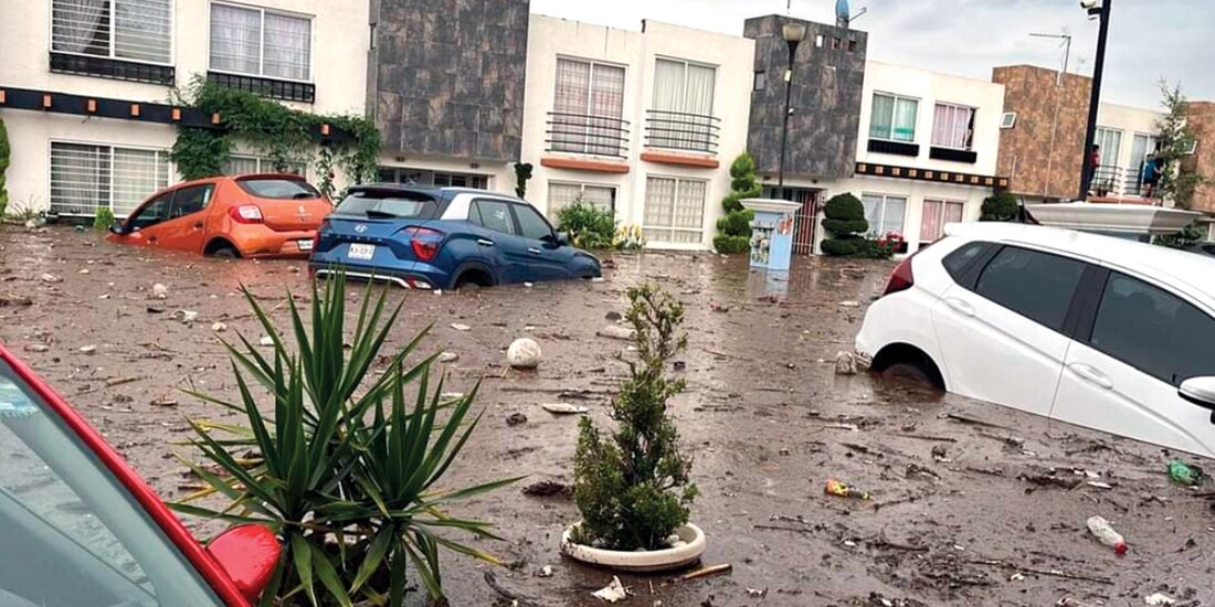 Autos en algunos fraccionamientos de Chalco quedaron cubiertos tras el desbordamiento del río San Martín, el jueves.