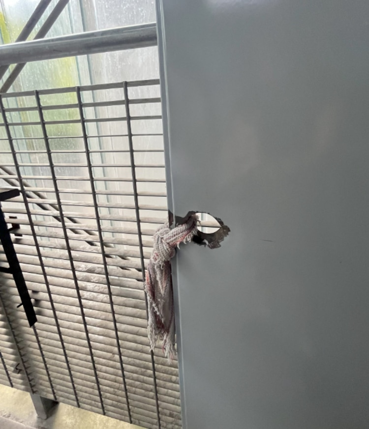 Una jerga en lugar de manija en la puerta principal de un baño de hombres.