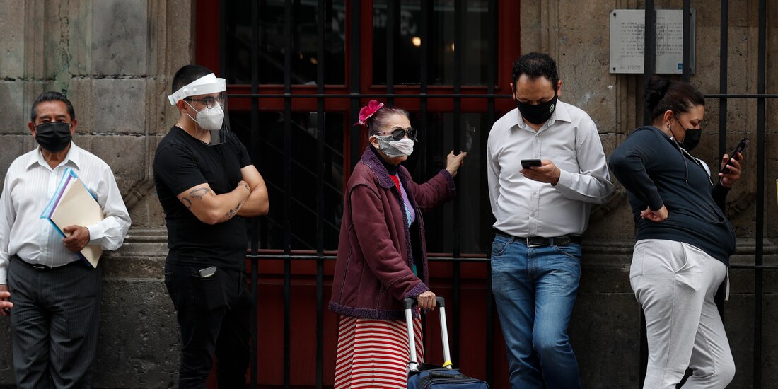 Personas con cubrebocas hacen fila antes de ingresar a un banco, el 6 de julio de 2020, en el centro de la Ciudad de México.