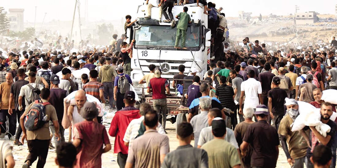 Palestinos recogen suministros, de camiones que ingresaron a través de Israel, ayer