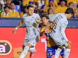 Diego Lainez intenta pasar entre dos jugadores en el duelo entre Tigres y Atlético de San Luis.