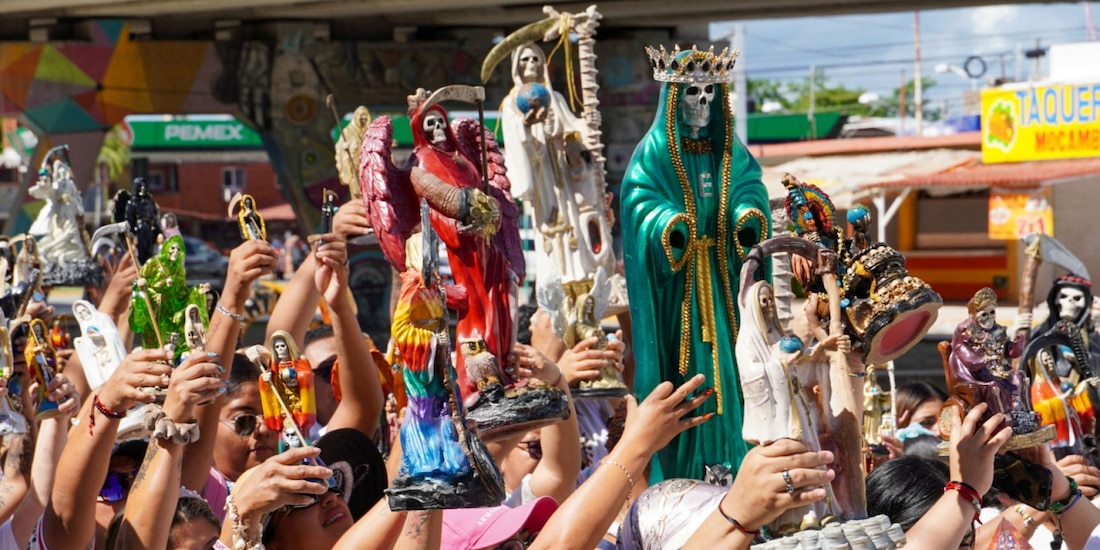 Fieles de la Santa Muerte reunidos para llevar a cabo el bautizo de sus figuras en las aguas del Caribe, en Puerto Juárez, Cancún.