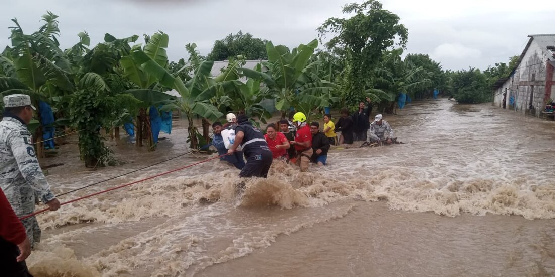 Elementos de la Guardia Nacional y de Protección Civil ayudan a pobladores a salir de La Providencia, ayer.