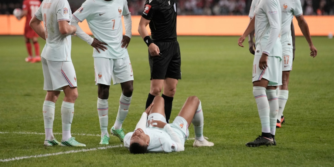 Kylian Mbappé tirado en el césped tras lesionarse.