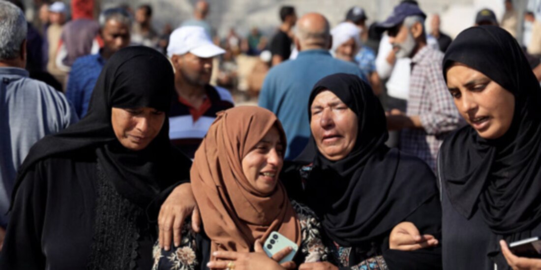 Dolientes reaccionan durante el funeral de palestinos asesinados, cerca de un sitio de distribución en Rafah, ayer.