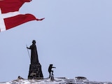 Un hombre camina mientras la bandera danesa ondea junto a la estatua de Hans Egede en Nuuk, Groenlandia, el 9 de marzo de 2025.