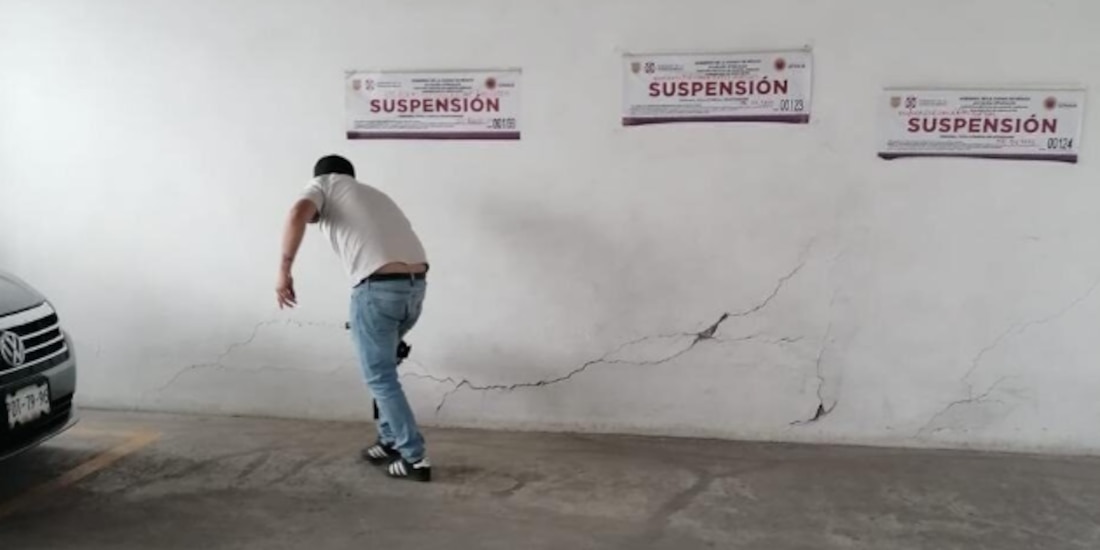 Un hombre observa las distintas grietas localizadas en el sótano del edificio, en días recientes.