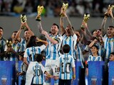 Lionel Messi y otros futbolistas de Argentina sostienen réplicas de la Copa Mundial de la FIFA que conquistaron en Qatar, después de su triunfo ante Panamá en Buenos Aires.