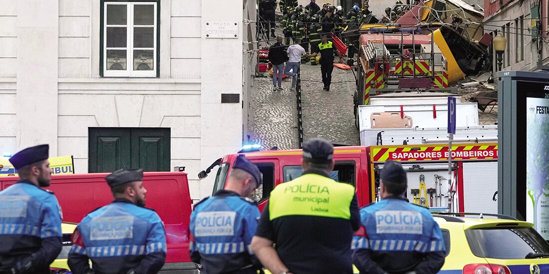 Equipos de emergencia trabajan en el lugar del descarrilamiento de un tranvía eléctrico en Lisboa, ayer.
