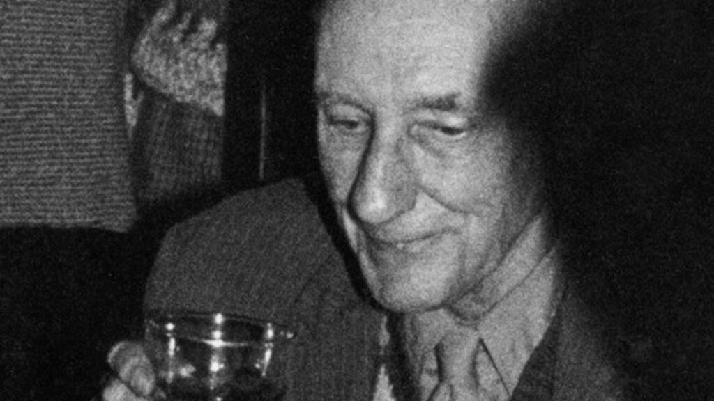 William Burroughs disfrutando de pastel y alcohol en su 70 cumpleaños.