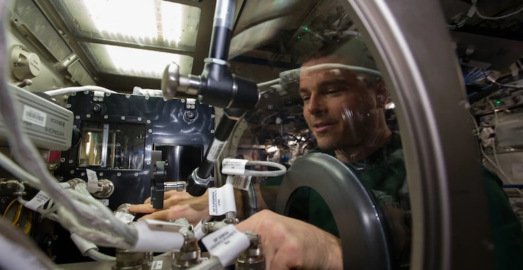 El astronauta de la NASA Reid Wiseman, ingeniero de vuelo de la Expedición 41, instala el hardware del experimento de Flujo Capilar en Canal (CCF, por sus siglas en inglés) en la Caja de Guantes Científica de Microgravedad (MSG, por sus siglas en inglés) ubicada en el laboratorio Destiny de la Estación Espacial Internacional.