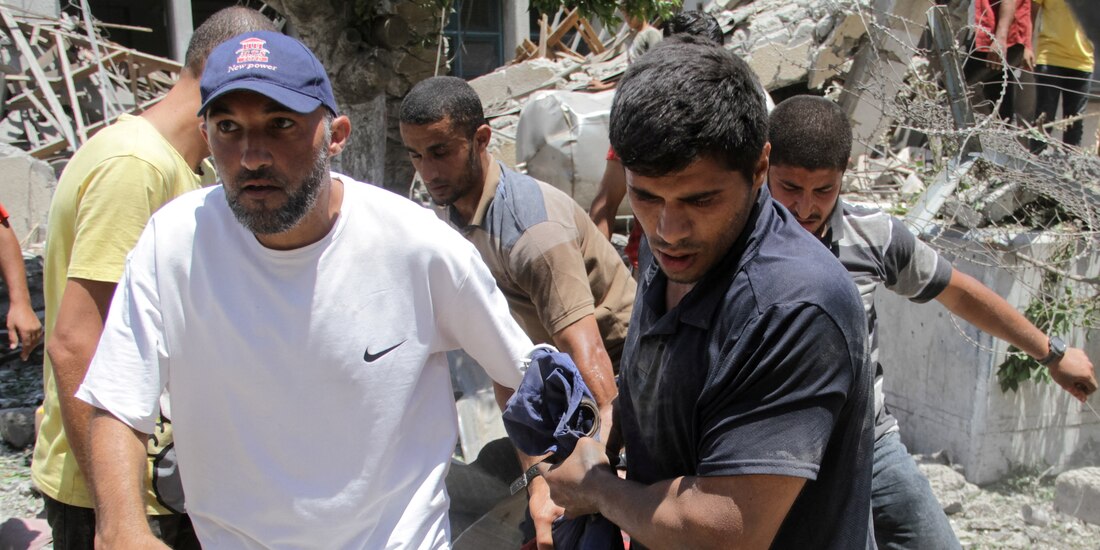 Residentes trasladan a una víctima herida tras otro bombardeo israelí en Gaza, ayer.