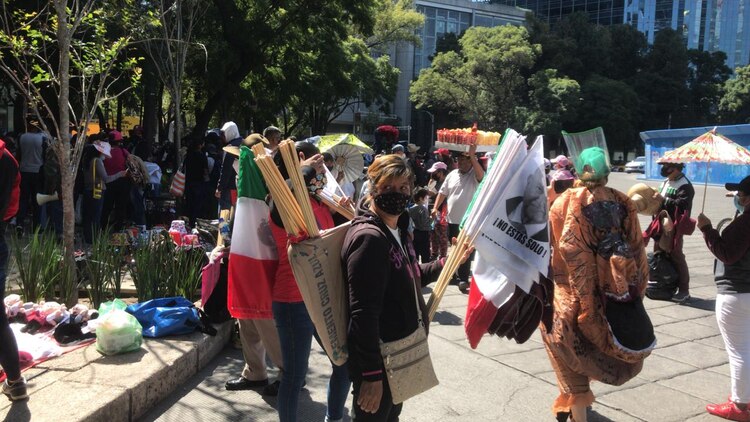 Una persona que vende banderas con mensajes en apoyo al Presidente de México.