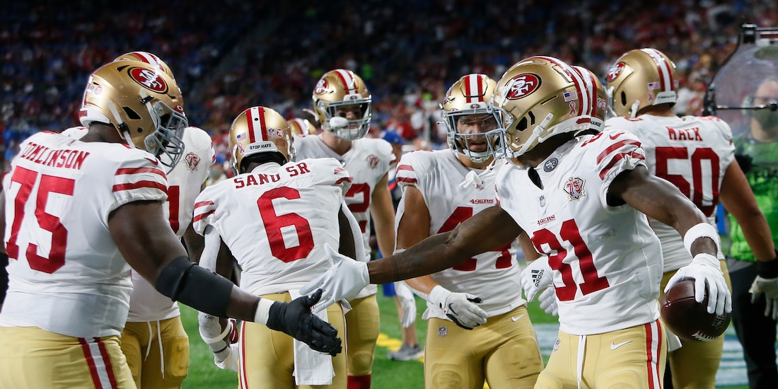 Jugadores de los 49ers de San Francisco celebran una anotación ante los Lions de Detroit