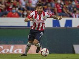 Alexis Vega conduce el balón en un partido de Chivas en la Liga MX.