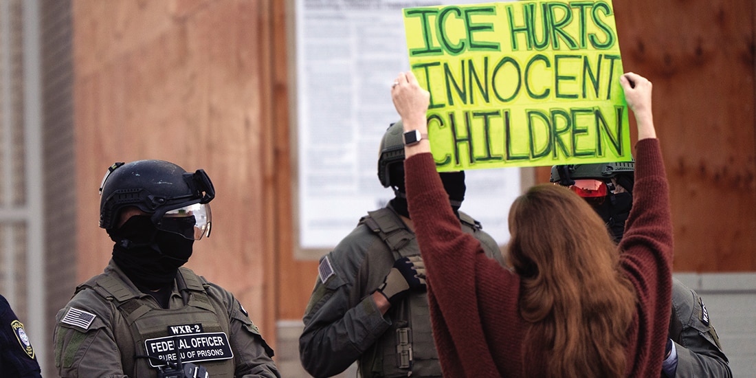 Un manifestante sostiene un cartel frente a agentes de ICE en Portland, Oregon, el 21 de octubre de 2025.