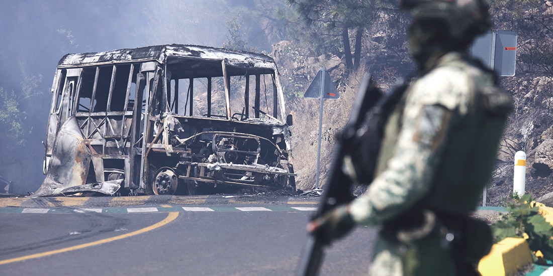Un militar hace guardia cerca de un vehículo quemado en Michoacán, el domingo.
