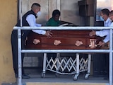 Trabajadores de una funeraria transportan hasta las puertas del Crematorio Nueva Vida, el cuerpo de una persona fallecida por Covid-19.
