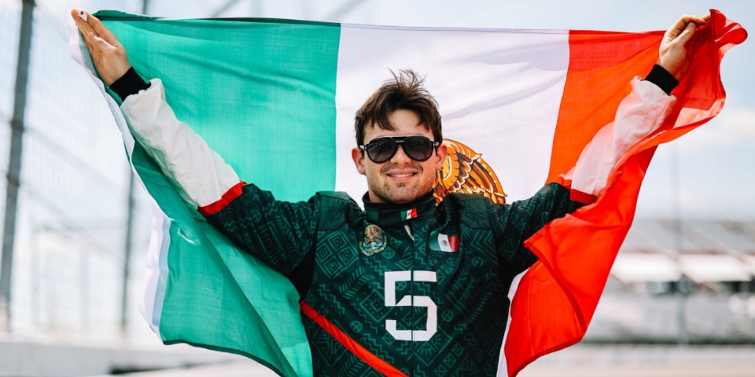 Pato O'Ward sosteniendo la Bandera de México.