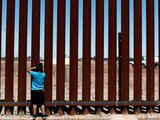 Un niño observa a través del muro fronterizo, en la frontera México-EU, en 2019.
