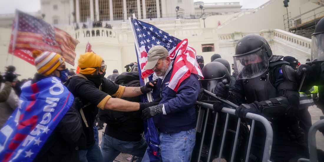 Manifestantes forcejean con policías en su intento de pasar la valla de seguridad, el pasado 6 de enero.
