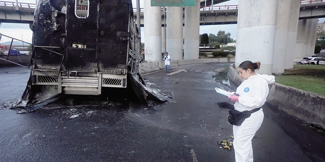 Peritos supervisan una de las unidades quemadas el miércoles, en Iztapalapa.